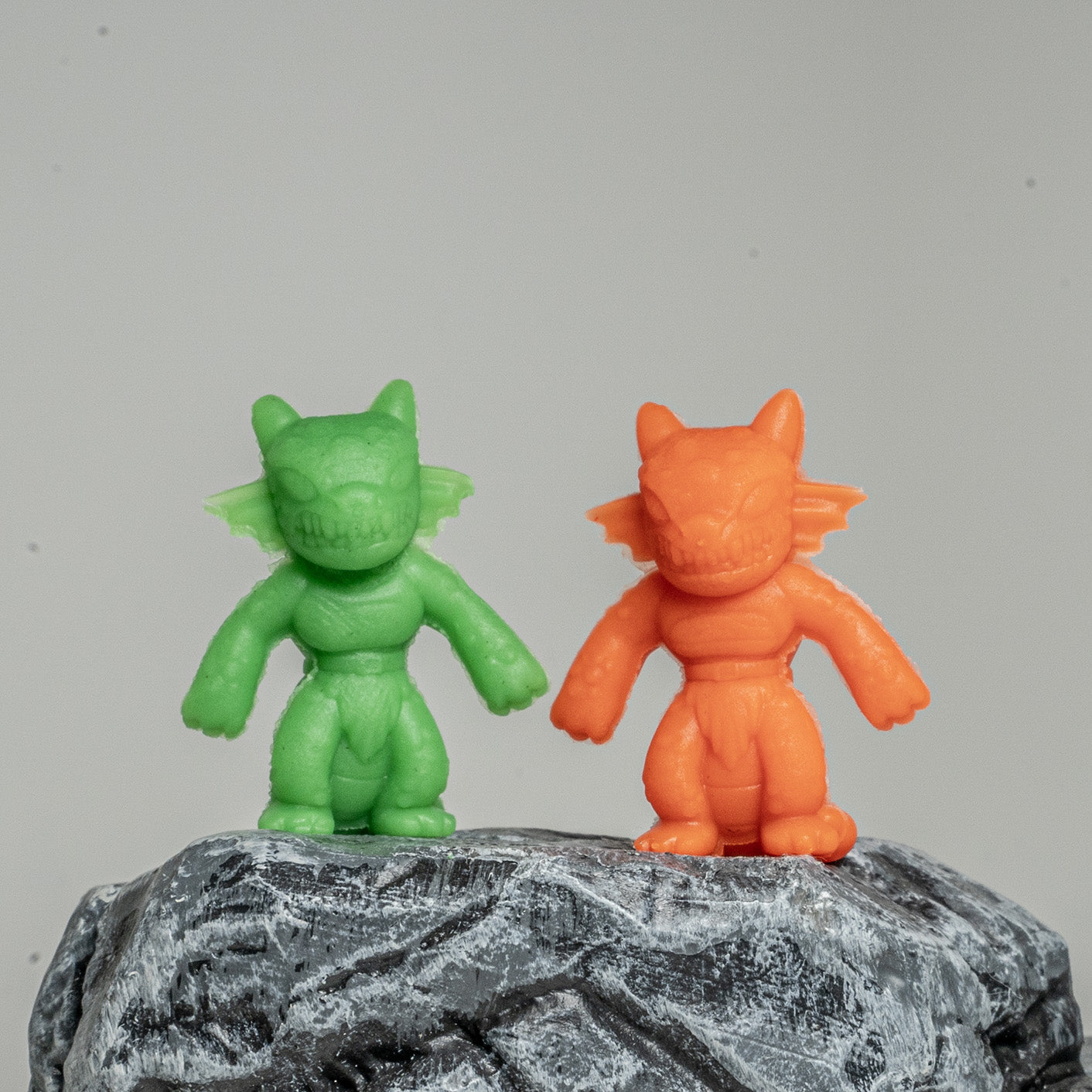 Two clay kobold miniatures standing on a rock